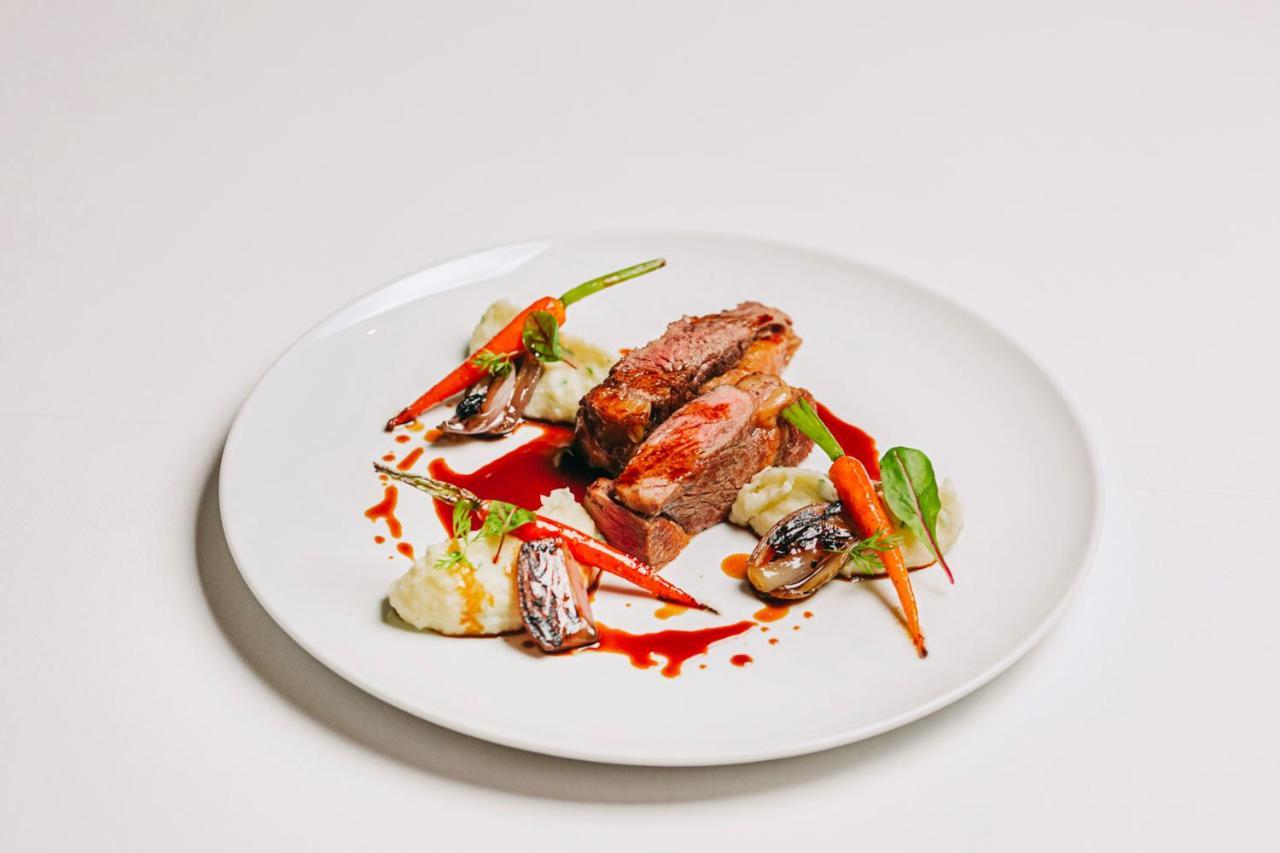 Ap Lago Montargil - Conference & Spa Екстериор снимка The photo features a beautifully plated dish. At the center, there are slices of a tender meat, likely beef, showcasing a juicy pink interior. Accompanying the meat are several elements: vibrant orange carrots, perhaps roasted or glazed, and dollops 