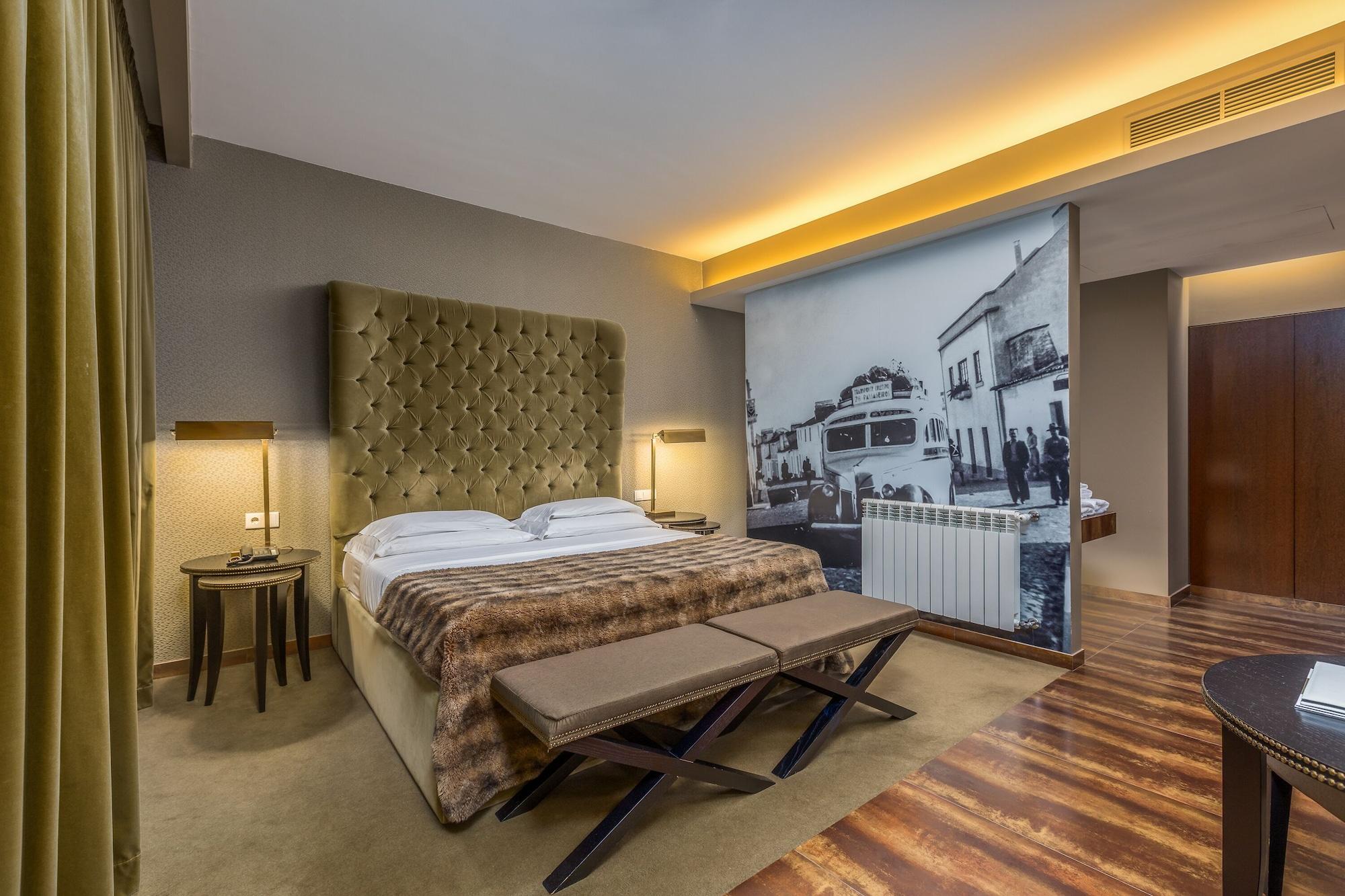Ap Lago Montargil - Conference & Spa Екстериор снимка The photo shows a modern hotel room featuring a king-sized bed with a tufted headboard, dressed in white linens and a decorative throw blanket. On either side of the bed, there are bedside tables with lamps. The room is well-lit, with an ambient ceil