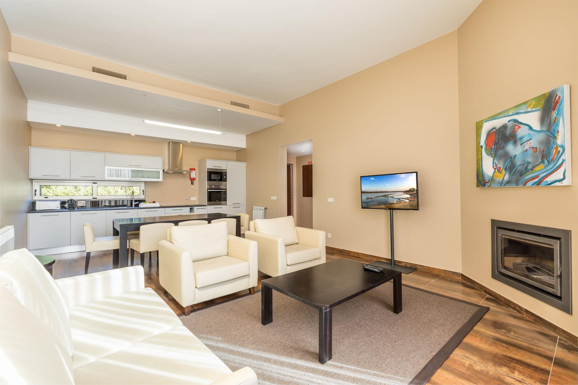 Ap Lago Montargil - Conference & Spa Екстериор снимка The photo shows a modern, spacious living area with a contemporary design. The room features light-colored walls and wooden flooring. 

In the center, there is a black coffee table surrounded by four white armchairs. A flat-screen TV is mounted on th